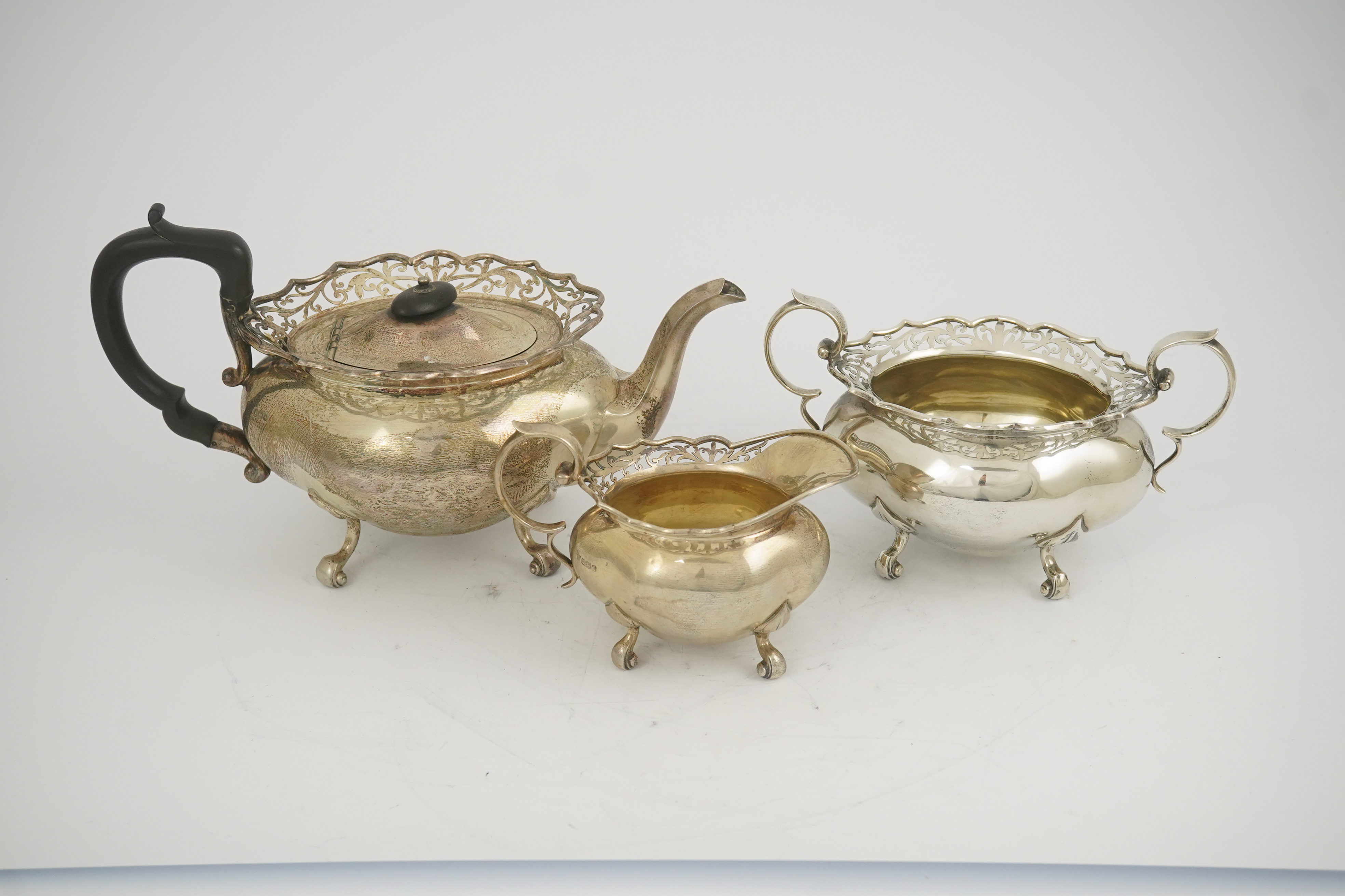 A George V three piece silver circular tea set by James Deakin & Sons